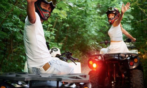 In the forest. Man and woman are on ATV outdoors In the forest. Man and woman are on ATV outdoors.